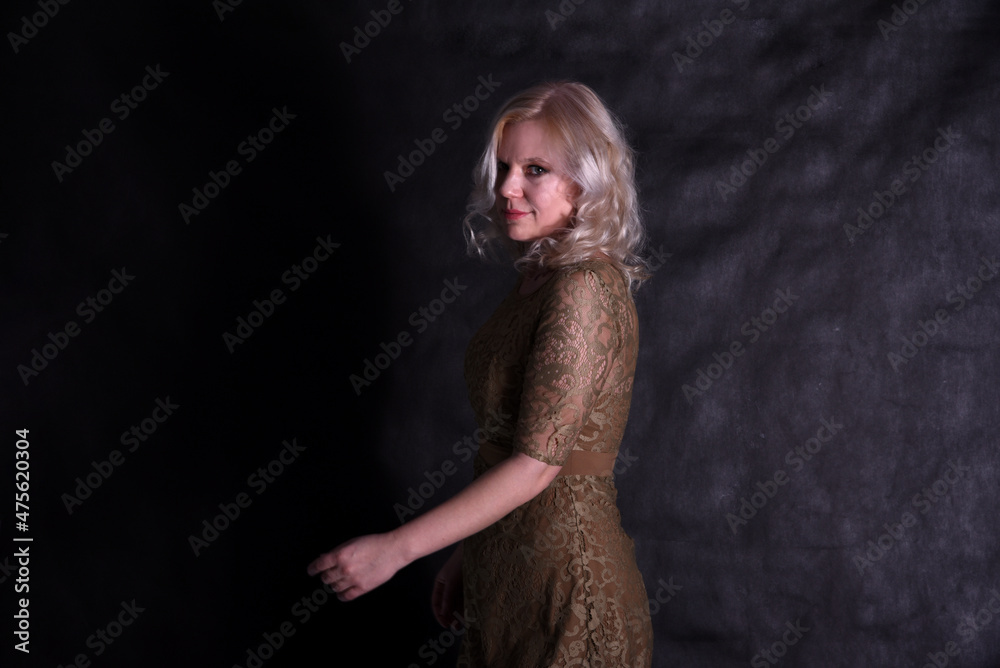 Portrait of a beautiful blonde on a black background in a studio in semi-darkness Portrait of a beautiful blonde on a black background in a studio in semi-darkness