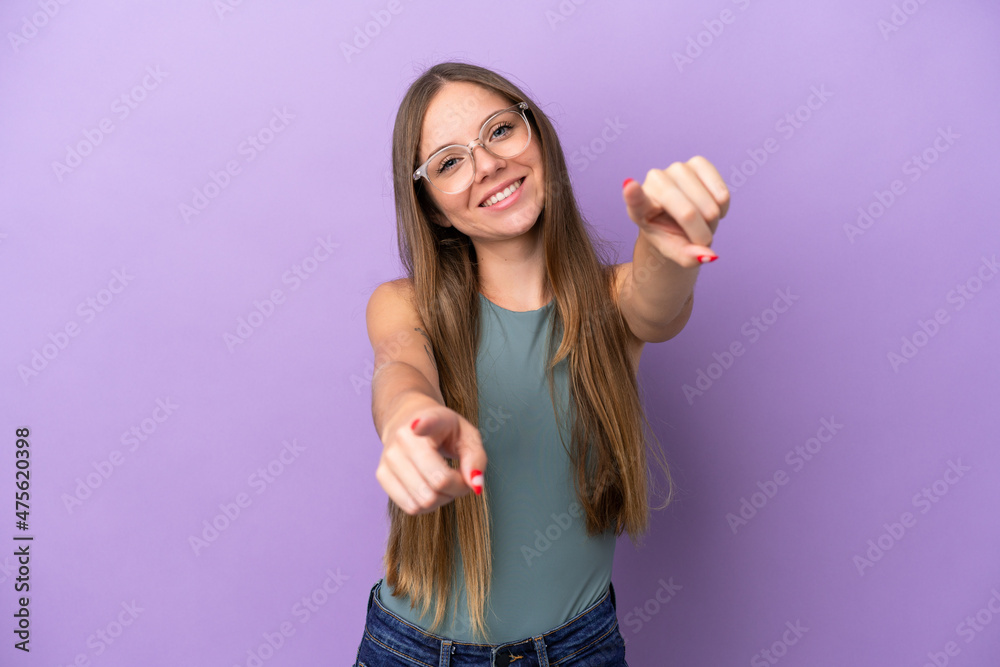 Fototapeta premium Young Lithuanian woman isolated on purple background pointing front with happy expression