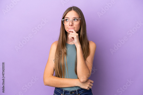 Young Lithuanian woman isolated on purple background having doubts and thinking