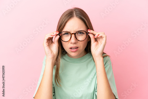 Young Lithuanian woman isolated on pink background With glasses and frustrated expression