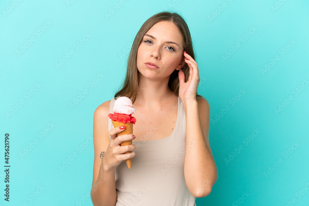 Young Lithuanian woman with cornet ice cream isolated on blue background having doubts Young Lithuanian woman with cornet ice cream isolated on blue background having doubts