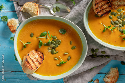 Healthy pumpkin soup with pumpkin seeds and crostini.