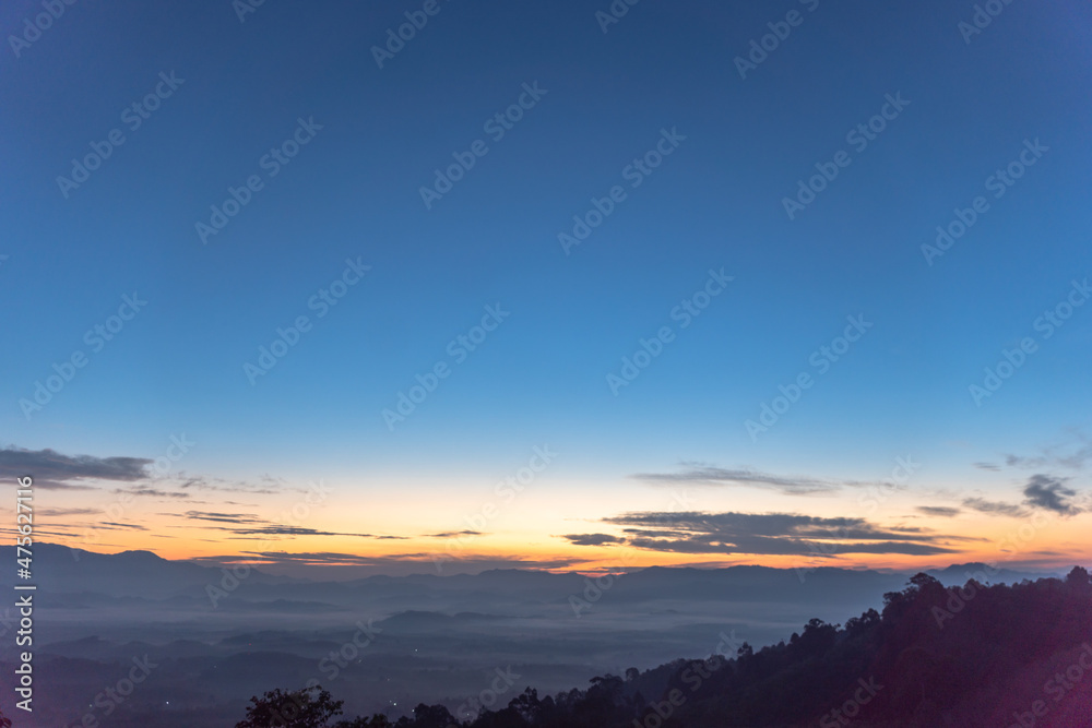 aerial view scenery sunrise above the mountain in tropical rainforest..slow floating fog blowing cover on the mountain look like as a sea of mist. .beautiful sunrise in the mist background. aerial view scenery sunrise above the mountain in tropical rainforest..slow floating fog blowing cover on the mountain look like as a sea of mist. .beautiful sunrise in the mist background.