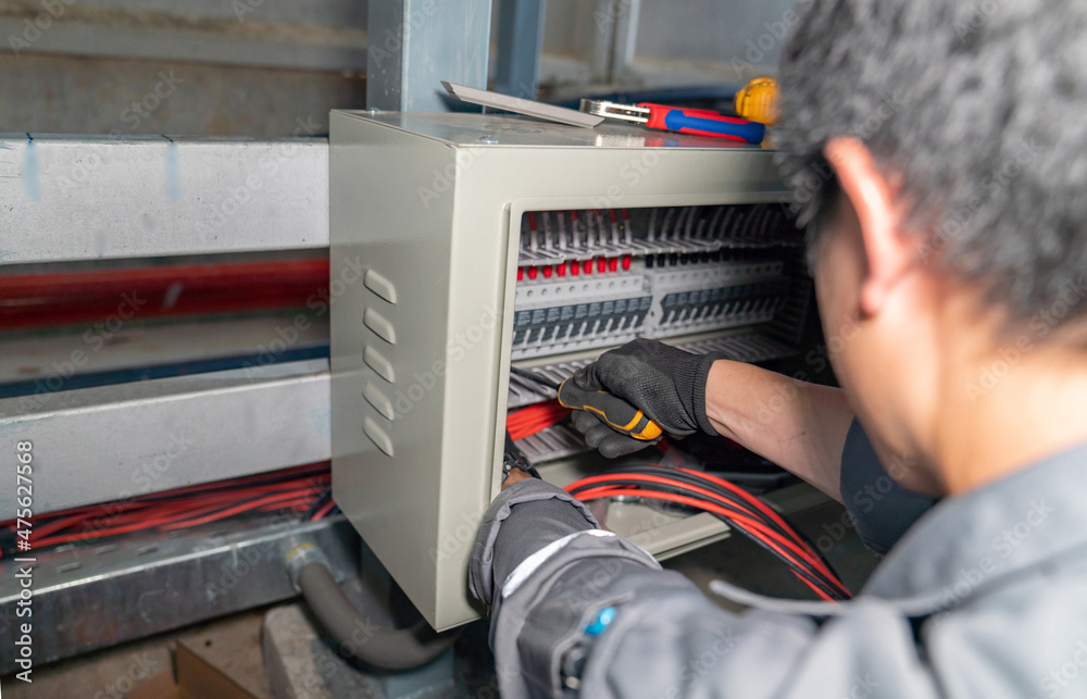 The engineer is connecting the power line from the solar panel to the fuse set. The engineer is connecting the power line from the solar panel to the fuse set.