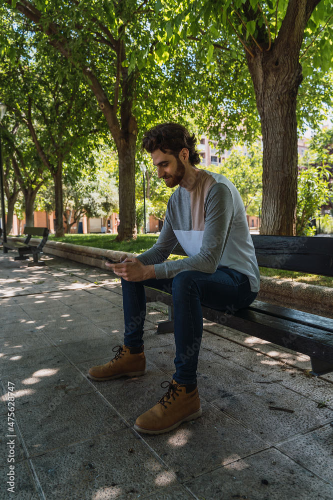 Man sitting in the park with the phone.