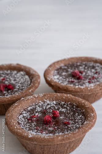 Close-Up of Delicious Chocolate Tarts on White Background with Copy Space Vertical