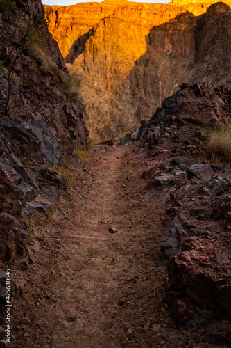 Narrow Dirt Path Of The River Trail With Morning Light Hitting The Distant Wall
