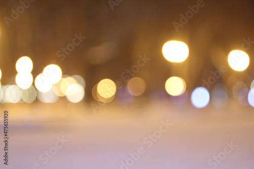 Blurred lights of lanterns in the park in winter. Shooting at night.