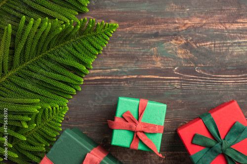 Christmas colorful gift box with pine leaf and decoration ornament on wooden table photo