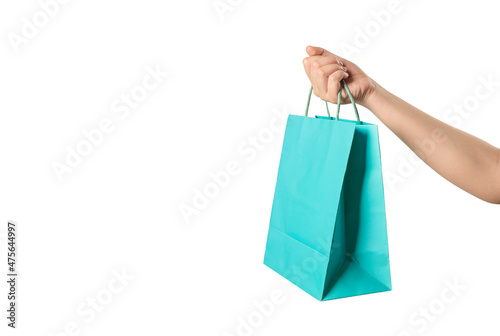 Hand holding shopping bag on white background.
