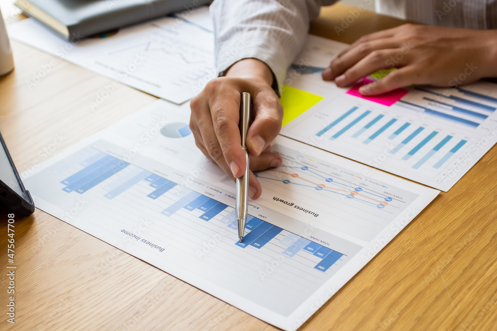 Young businessman pointing to last quarter's earnings and planning revision of business finances next quarter, businessman pointing to past company volatility, businessman planning ideas. Young businessman pointing to last quarter's earnings and planning revision of business finances next quarter, businessman pointing to past company volatility, businessman planning ideas.