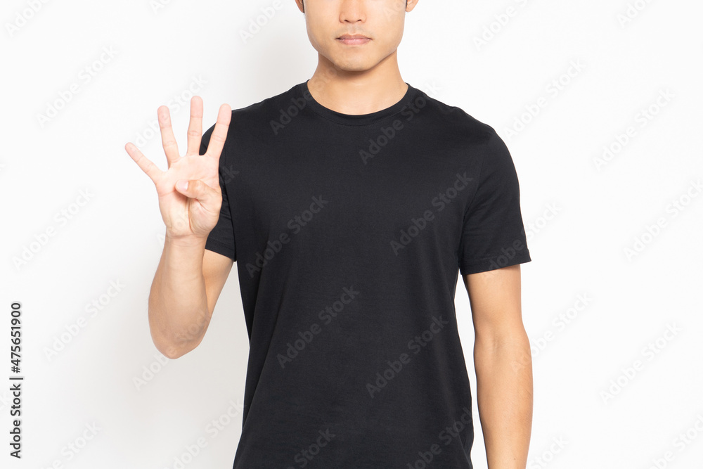 白い背景の前に立って、手で数字の4を表す黒いTシャツを着ている男性 白い背景の前に立って、手で数字の4を表す黒いTシャツを着ている男性
