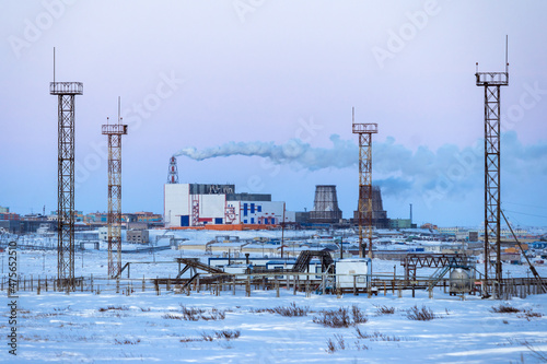 Winter industrial landscape. A view of the towers and structures of a gas-pumping station in the tundra and a large combined heat and power plant. Industry and Energy in the Arctic. Chukotka, Russia.