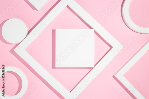 White presentation podiums geometric shapes on a pink background. Top view, flat lay