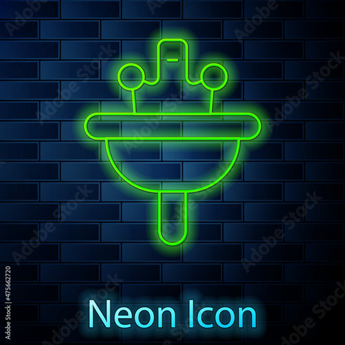 Glowing neon line Washbasin with water tap icon isolated on brick wall background. Vector