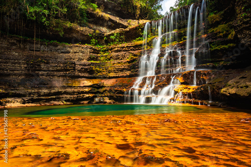 Vászonkép waterfall streams falling from mountain with blurred water surface at morning fr