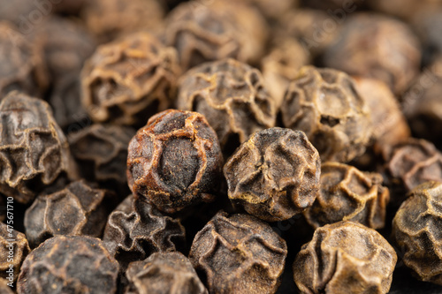 macro of true edible spices and seeds: black peppercorn on a pile.( black pepper - Piper nigrum)