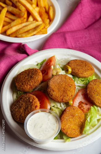 Plate of falafel with salad and tzatziki sauce. View from above, vertical image