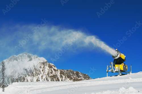 Snow-gun spraying artificial ice crystals. Machine making snow. photo