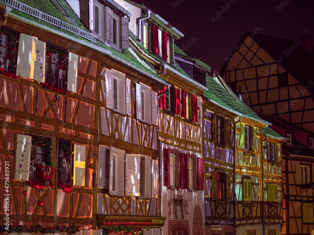 Christmas in Colmar, Alsace, France - illuminated colorful facades of traditional old houses.