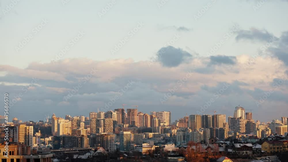 Time Lapse shot of city with sunlight and clouds floating in sky over buildings