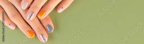 Photographie Close up womans hands with trendy minimal manicure on green background