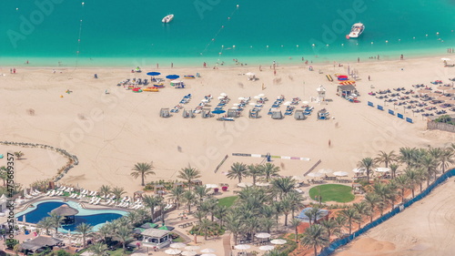Crowded JBR beach with tourists enjoying the sun and the sea, sitting under umbrellas aerial top view from above timelapse © neiezhmakov