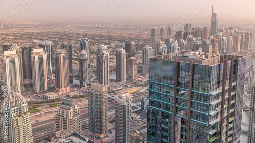 Dubai Marina and JLT district with traffic on highway between skyscrapers aerial timelapse.