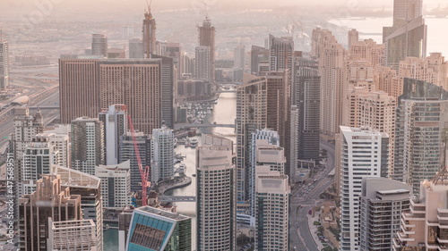 Skyline panoramic view of Dubai Marina showing an artificial canal surrounded by skyscrapers along shoreline timelapse. DUBAI, UAE