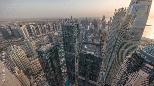 Dubai Marina and JLT district with traffic on highway between skyscrapers aerial timelapse.