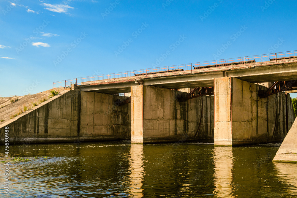 Dam on the Oskol river, Belgorod region, Russia. River surface with concrete banks. Dam on the Oskol river, Belgorod region, Russia. River surface with concrete banks.