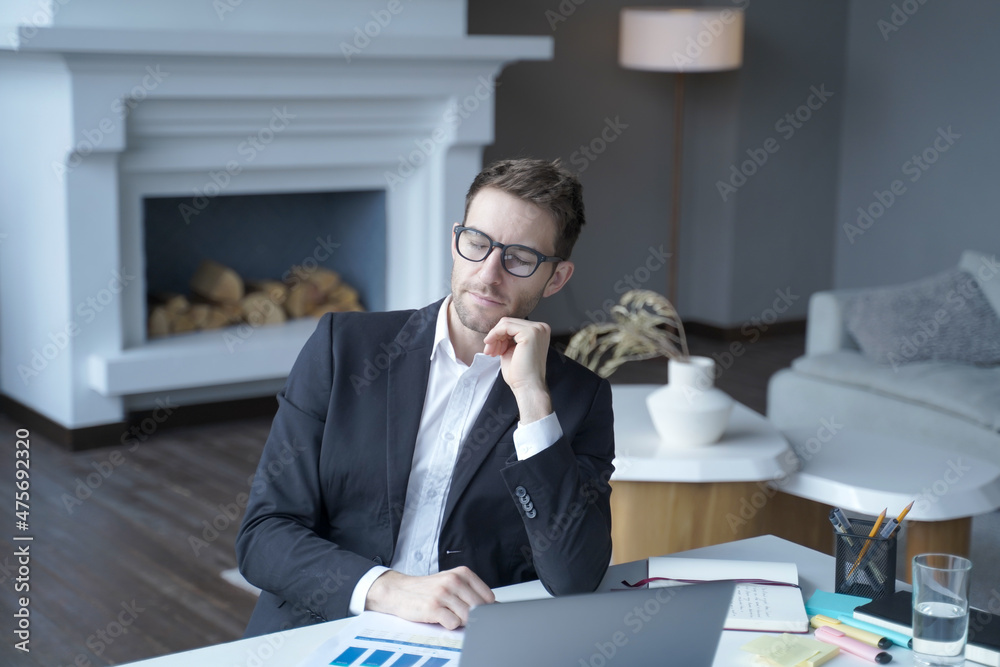 Restful businessman in formal wear sit at home office with closed eyes while working remotely online Restful businessman in formal wear sit at home office with closed eyes while working remotely online