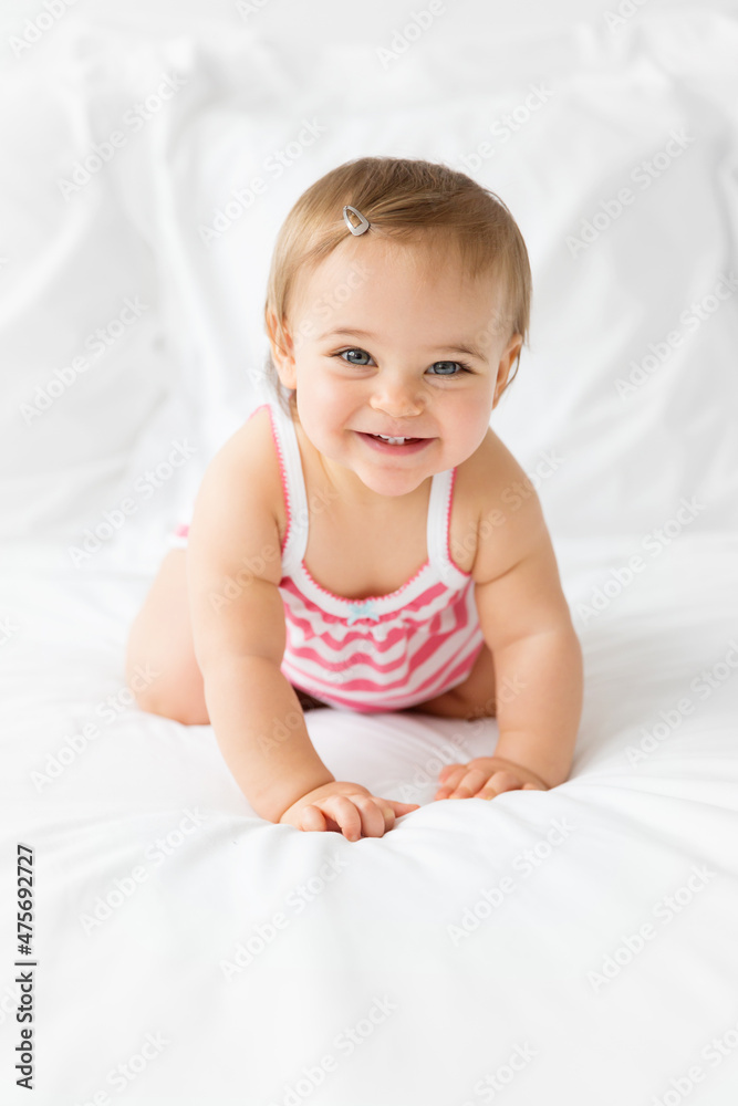 cute smiling baby girl crawling on white bed cute smiling baby girl crawling on white bed