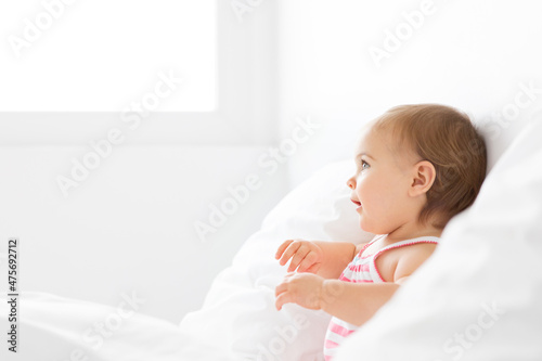 Profile portrait of baby girl next to bedroom window