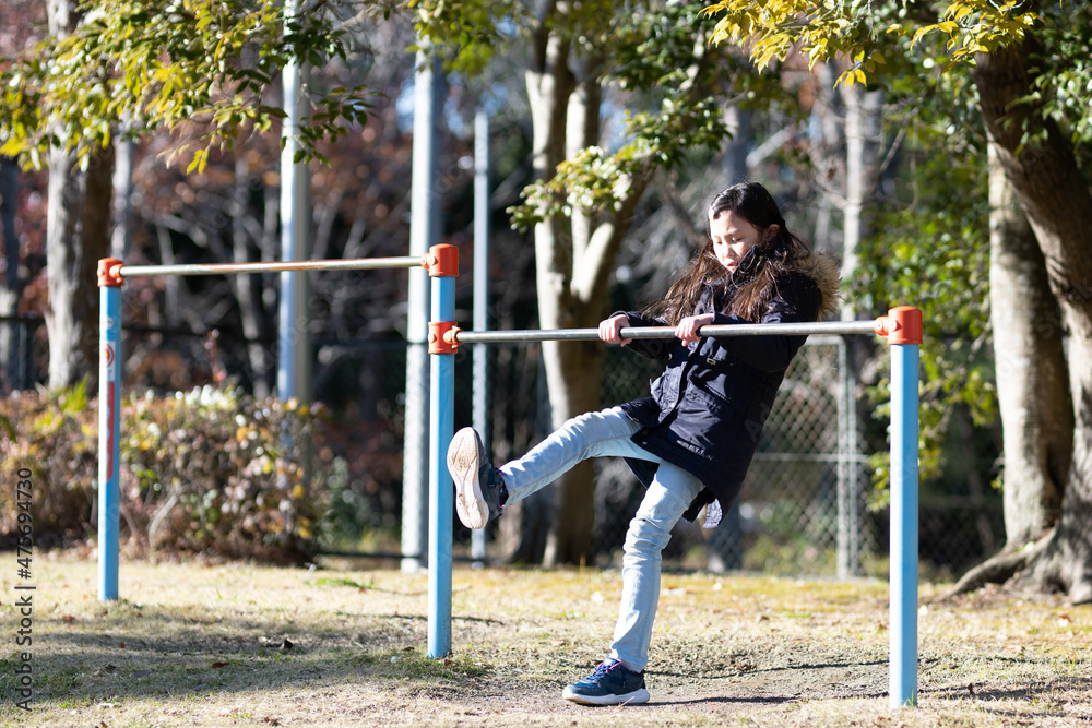 Obraz premium 鉄棒で遊ぶ少女