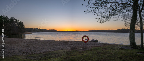 Morning view at sunrise at the empty winter beach Kanaan Badet, silhouettes and reflections at the lake Mälaren in the district Bromma a sunny day in Stockholm photo