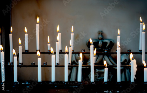 Quadro su tela Religion background with burning white candles on fireplace at Church