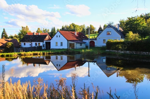 A beautiful water reflection of houses in the small village during sunset at Horni Radikov, Czech republic photo