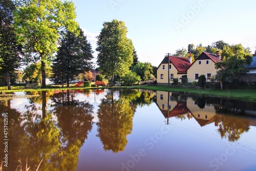 A beautiful water reflection of houses in the small village during sunset at Horni Radikov, Czech republic