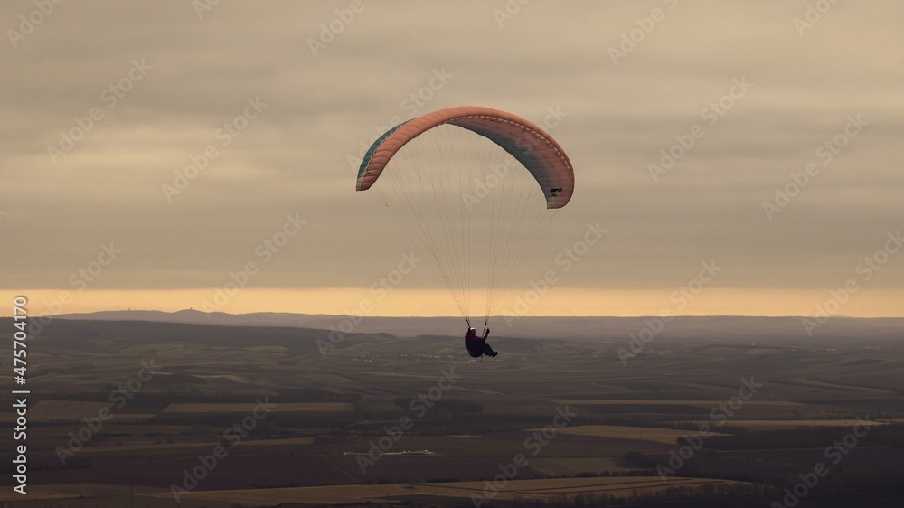 Paragliding above the landscape during the sunrise near Mikulov, Czech republic