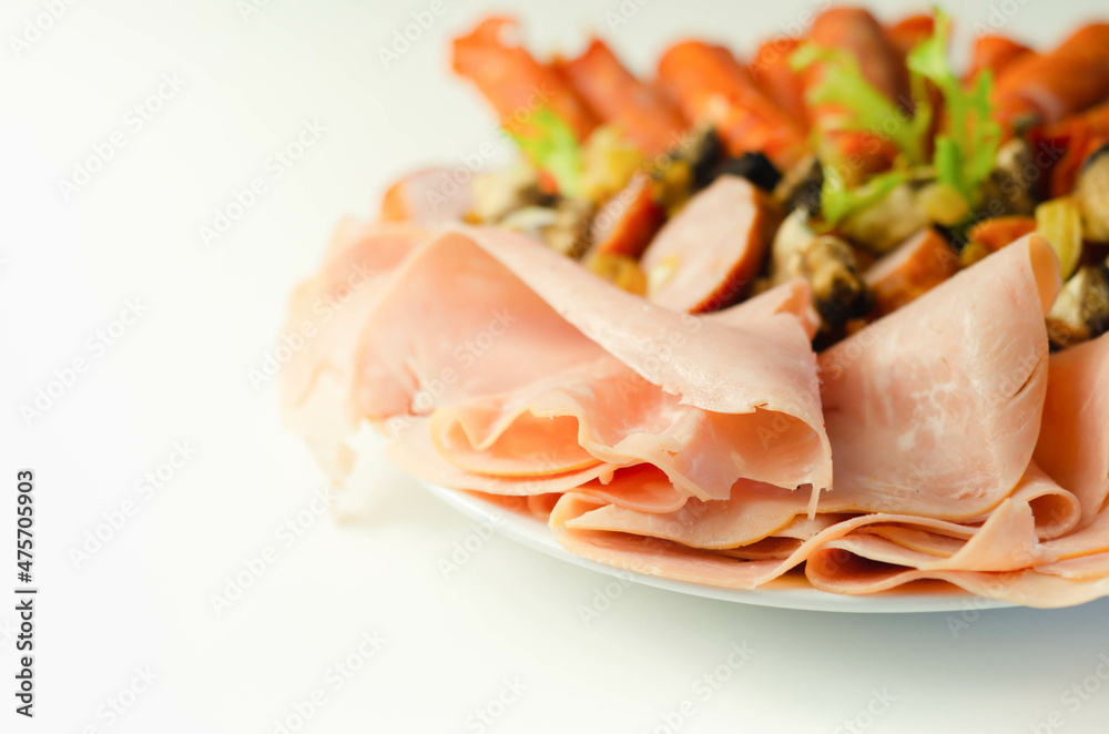 A cold plate prepared for the party with sliced chorizo, ham and sausages A cold plate prepared for the party with sliced chorizo, ham and sausages