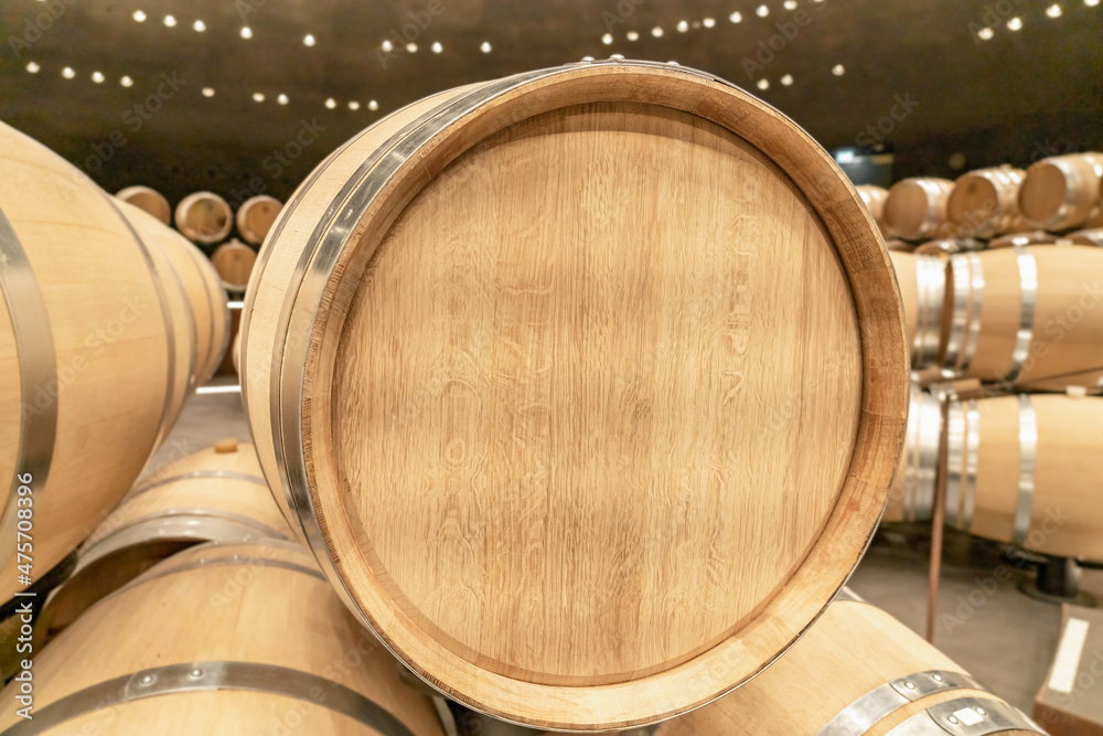 Yellow oak barrel with stainless steel rings at a winery for making wine. Advertising space, copy space