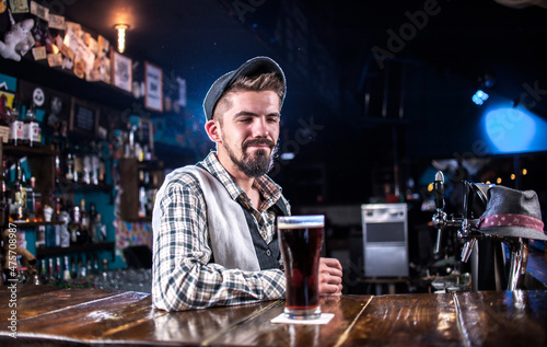 Bearded bartending makes a show creating a cocktail at bar