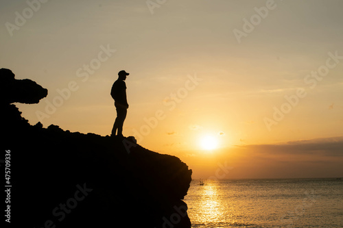 silhouette of a man alone on a rock enjoy the sunset 