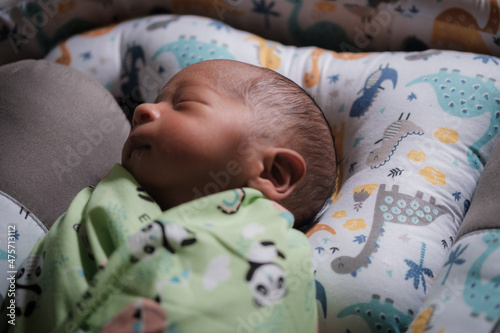 A newborn baby is sleeping comfortably with an adorable expression. Asian child two days old. 