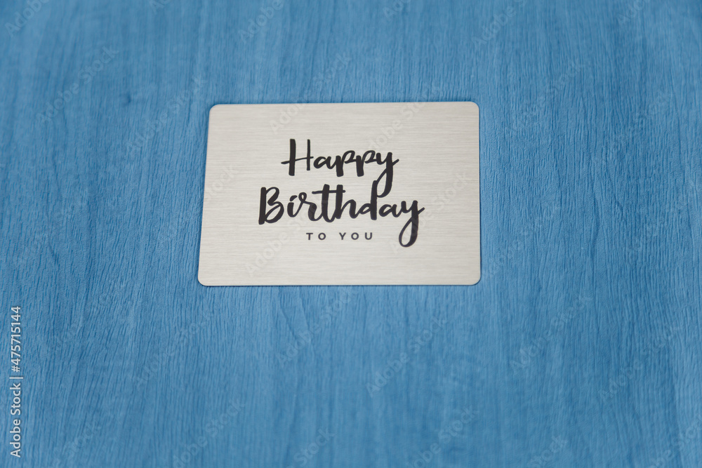 Photobook, photoalbum in blue leather cover with metallic shield and inscription Happy Birthday to you. Close up Photobook, photoalbum in blue leather cover with metallic shield and inscription Happy Birthday to you. Close up