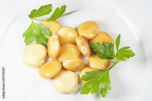 lupins or lupini beans on white plate with parsley leaves