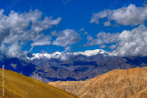 Beautiful Himalayan landscape of Ladakh with blue sky, clouds and ice peaks in background , Ladakh, Jammu and Kashmir, India