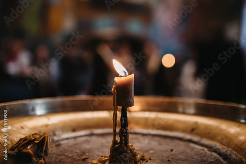 Selective closeup of a burning candle in a church photo