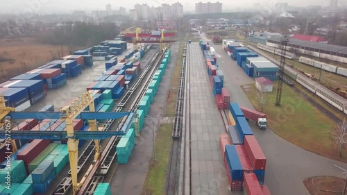 Multicolored freight containers at the railway customs. Aerial drone flight over.